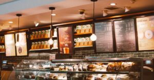 Warm and inviting café interior with a modern design, featuring a well-stocked counter and stylish lighting.