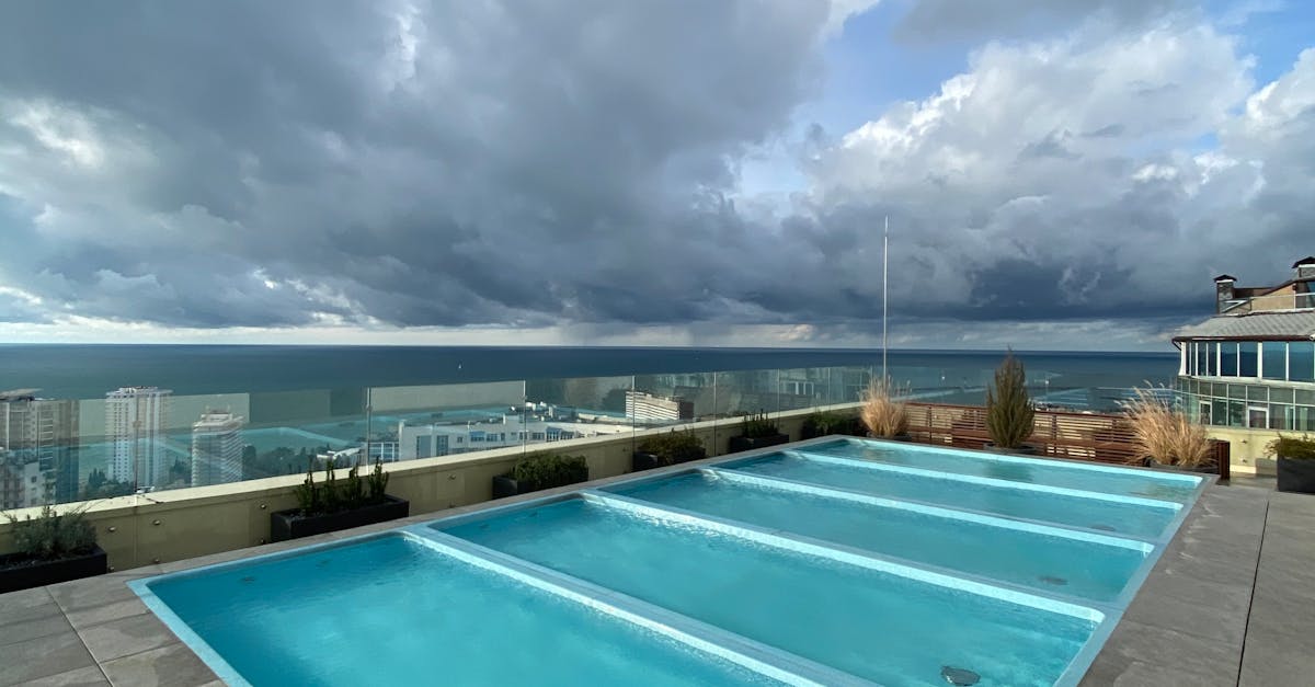 Rooftop pool with a scenic view of Sochi's skyline under dramatic cloudy skies.
